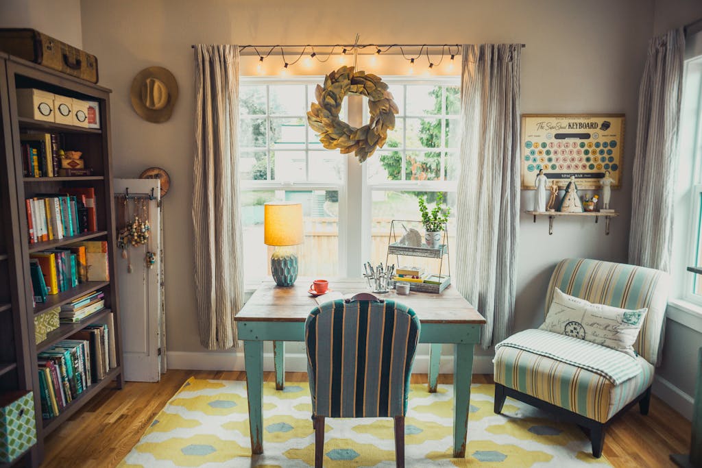 A bright and cozy home office with vintage decor, bookshelves, and natural light.