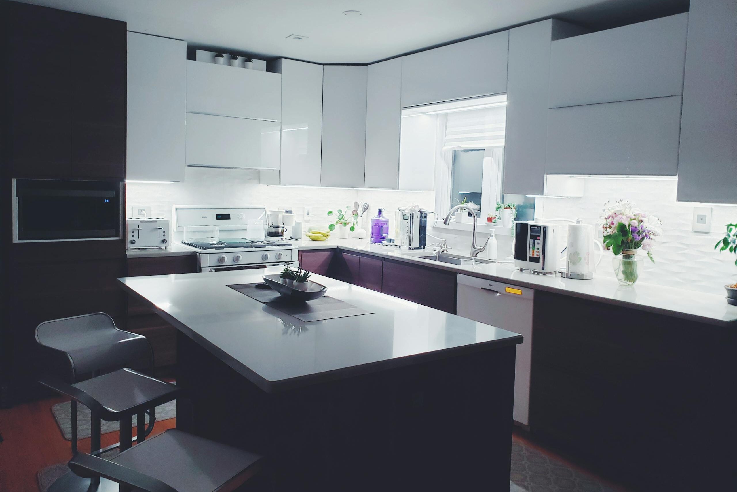 Contemporary kitchen interior with sleek white cabinets and island, perfect for a minimalist aesthetic.