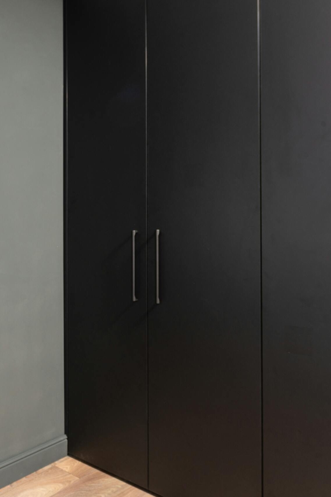 Stylish interior with a minimalist wardrobe, grey door, and modern lighting fixture.
